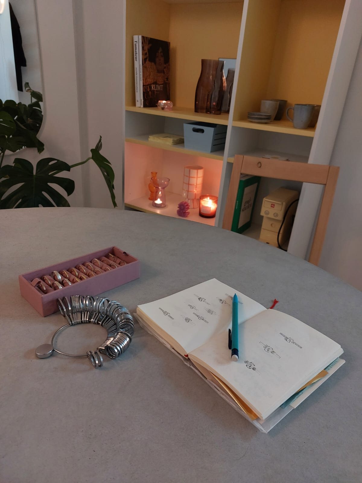 Ringmaten, schetsboek en proefringen op de tafel in het atelier