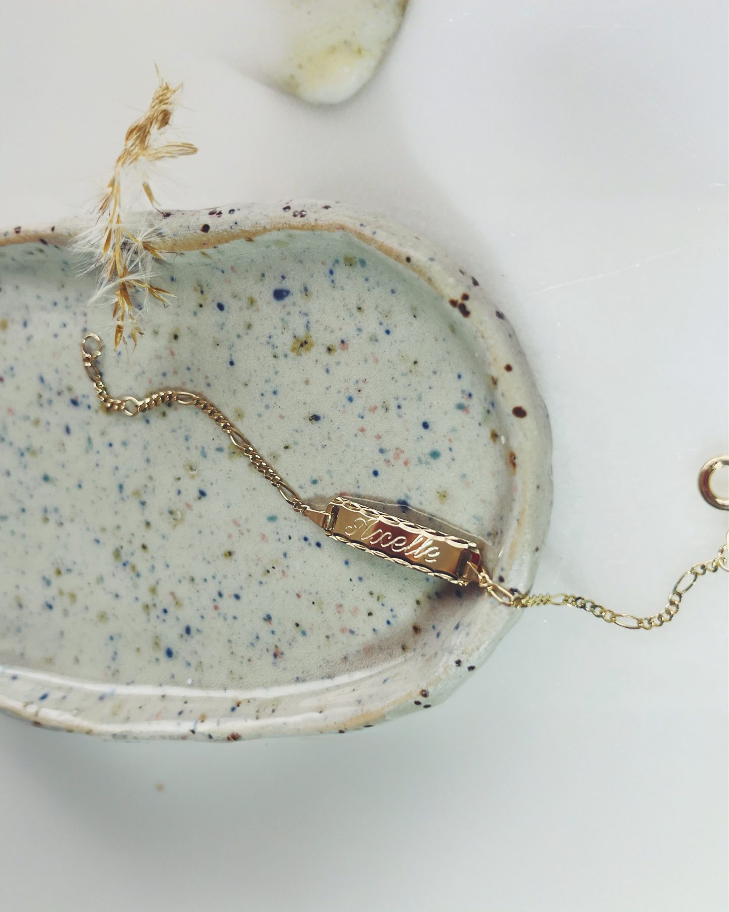 Gouden armbandje op een keramisch schaaltje