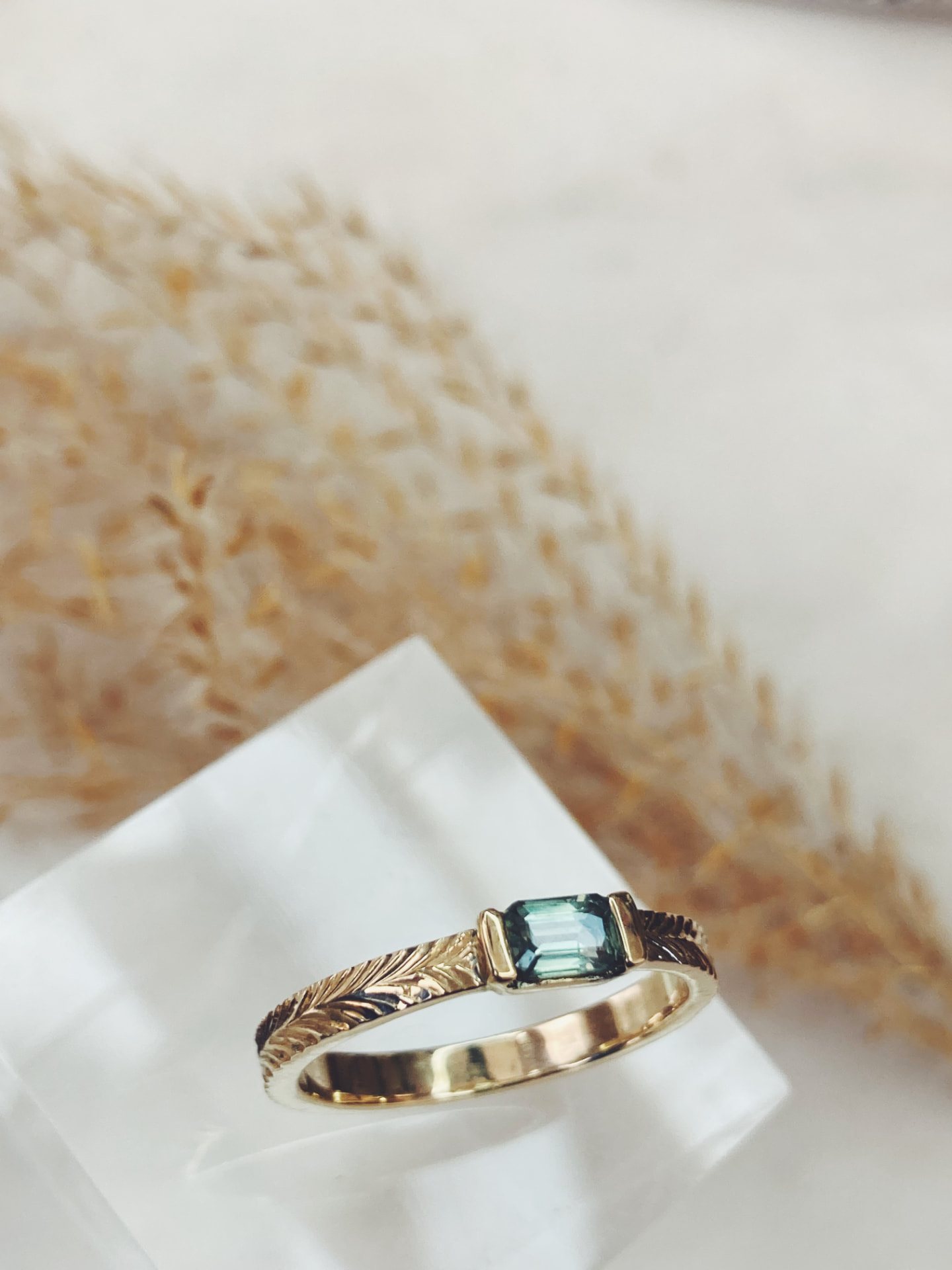 Gegraveerde gouden ring met groene steen in emerald-slijpvorm