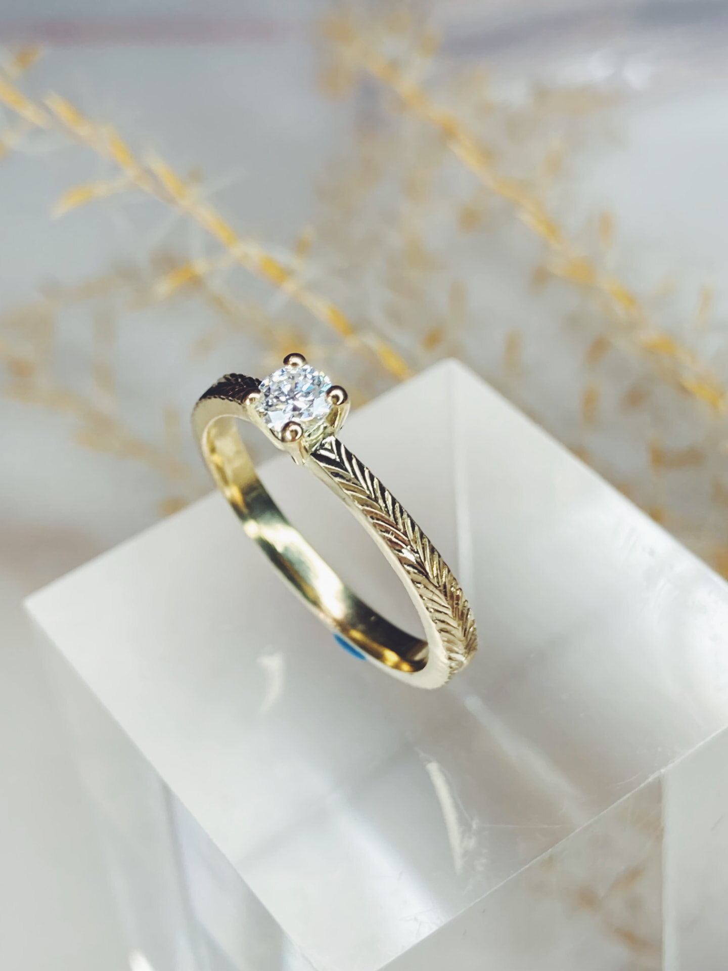 Geelgouden verlovingsring met solitaire diamant en gegraveerd visgraatmotief
